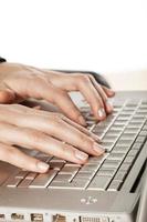 Damenfinger berühren die Tastatur des Laptops