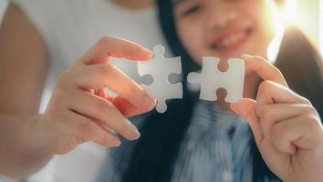 glückliche familie, asiatische tochter, die mit ihrer mutter für familienkonzept puzzle spielt, erwachsene frau lehrt kind, rätsel zu lösen, erfolg und strategiekonzept foto