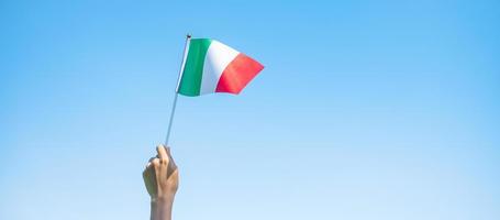 Hand, die Italien-Flagge auf Naturhintergrund hält. nationaltag, republiktag, festa della repubblica und fröhliche feierkonzepte foto