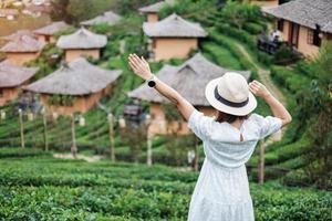glückliche touristenfrau im weißen kleid genießen schönen teegarten. reisenderbesuch im thailändischen dorf ban rak, mae hong son, thailand. Reise-, Urlaubs- und Urlaubskonzept foto