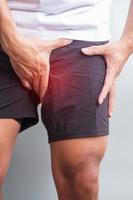 erwachsener mann mit muskelschmerzen beim laufen. Läufer haben Beinschmerzen aufgrund von Leistenzerrung, Liotibial-Band-Syndrom oder Prostatakrebs. sportverletzungen und medizinisches konzept foto