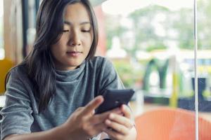 Frauen nutzen das Smartphone für geschäftliche Zwecke im Café
