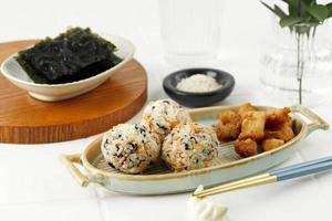 Koreanische Algenreisbällchen oder Jumeokbap mit Schinken, Wurst, Sesamsamen, Sesamöl und Gemüse foto