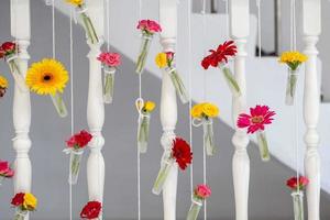 DIY schöne Blume in der kleinen transparenten Glas- und Plastikflasche hängen an der Treppenterrasse. foto