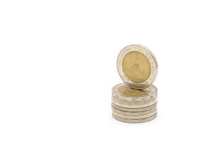 10-Baht-Münzen die thailändische Silber- und Goldfarbe in der Münze, mit Tempelzeichen darin auf weißem Hintergrund. Beschneidungspfad. foto