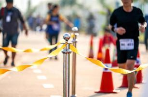 Luxus-Edelstahlbarrikade mit gelbem Seilband auf der Straße im Marathon-Event am Zielpunkt. foto