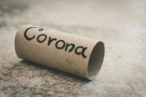 letztes stück toilettenpapierrolle auf dem boden mit handgezeichnetem wort corona foto