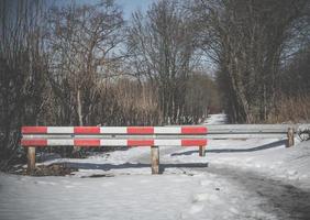 Barriere über einer verschneiten Winterstraße foto