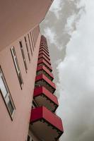 ein Hochhaus mit kleinen roten Balkonen mit Blick von unten foto