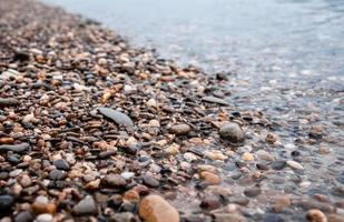 Wasser abgenutzte Kiesel am Rand eines Sees foto