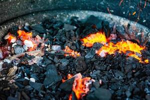 Holzkohle auf einem Grill mit Feuer foto