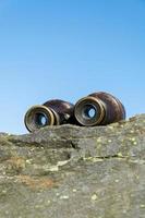 altes Fernglas auf einem Felsen foto