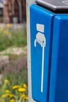 blaue Tonne im Freien in einer Straße mit Hand mit Stock foto