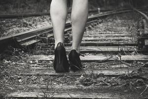 Frau mit High Heels auf einer Bahnstrecke foto