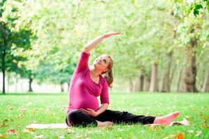 schwangere Frau, die Yoga am Hyde Park, London spielt