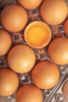 Zerbrochene Eier und Hühnereigelb in Plastikbox foto