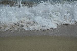 Strandwellen und Sand foto