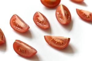 in Scheiben geschnittene rote Tomate auf weißem Hintergrund foto