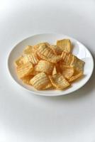 leckere Kartoffelchips mit Pfeffer auf einem weißen Teller foto