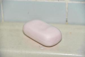 Rosa Seife in einem schmutzigen Badezimmer auf dem Waschbecken foto