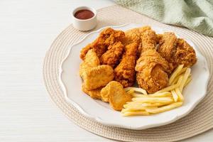 Brathähnchen mit Pommes Frites und Nuggets auf Teller foto