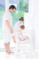 glücklicher Vater mit Kindern nächste Runde Krippe beobachten Neugeborenes