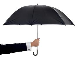 ein schwarzer Regenschirm auf weißem Hintergrund, der von einem Arm gehalten wird foto
