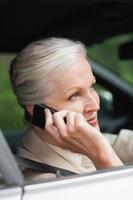 friedliche Geschäftsfrau am Telefon fahren nobles Auto