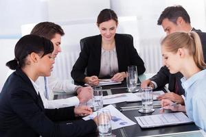 Geschäftsleute sitzen am Konferenztisch foto