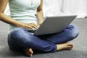 junge Frau sitzt beim Verwenden des Laptops