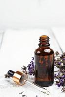 trockener Lavendel und Öl auf einem weißen Holztisch foto
