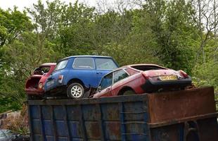 ungewöhnlicher Automüllcontainer voller weggeworfener Fahrzeuge foto