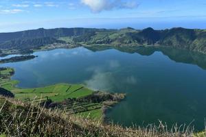 reflexionen von hügeln und wolken im blauen see von sete cidades foto