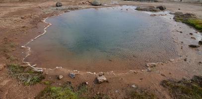 heißer Quellgeysir mit mineralischen Ablagerungen um ihn herum foto