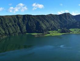 grüne Klippen und Hügel, die den blauen See umgeben foto