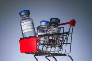 Covid-19-Booster-Impfstofffläschchen im Einkaufswagen. medizin- und gesundheitskonzept foto
