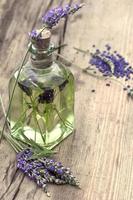 ätherisches Kräuter-Lavendelöl mit frischen Blumen foto