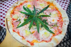 Pizza eine Mischung aus Cannabisblättern, entwickelt für Gesundheitsliebhaber in einer neuen, lizenzierten und legalen Form. garantierte Sicherheit, helfen, Angst zu lindern, Traurigkeit zu reduzieren. Konzept Cannabis für die Gesundheit. foto