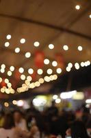 unscharfer Hintergrund des Lebensmittelmarktes mit hängenden Glühlampen foto