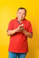 Fotoporträt des asiatischen Großvaters fröhlich glücklich Händeklatschen auf Konzert isoliert gelber Hintergrund foto