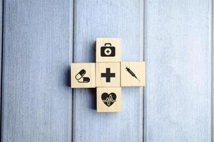 Krankenversicherungskonzept, Holzklötze mit medizinischer Ikone im Gesundheitswesen, blauer Hintergrund foto