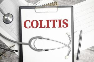 Colitis-Wort und Stethoskop auf Holzhintergrund foto