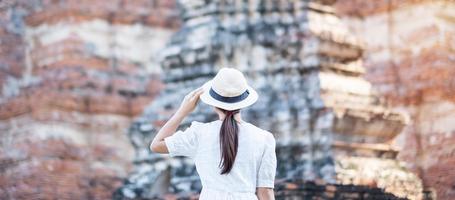 touristische frau im weißen kleid, das alten stupa im wat chaiwatthanaram-tempel im ayutthaya-historischen park, sommer-, asien- und thailand-reisekonzept besucht foto