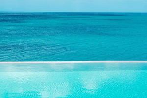 Infinity-Pool im Luxushotel am Meer, tropisches Resort. entspannendes, sommer-, reise-, urlaubs-, urlaubs- und wochenendkonzept foto