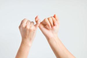 Zwei Hände haken den kleinen Finger zusammen. foto