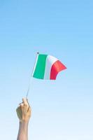 Hand, die Italien-Flagge auf Naturhintergrund hält. nationaltag, republiktag, festa della repubblica und fröhliche feierkonzepte foto