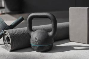 Kettlebell und Yogamatte zu Hause auf dem Boden. Fitnessgeräte. foto