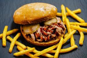 scharfes Pulled Pork mit goldenen Pommes foto