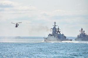 schlachtschiffe kriegsschiffe korvette während marineübungen und hubschrauber manövrieren über meer, kriegsschiffe foto