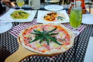 Pizza eine Mischung aus Cannabisblättern, entwickelt für Gesundheitsliebhaber in einer neuen, lizenzierten und legalen Form. garantierte Sicherheit, helfen, Angst zu lindern, Traurigkeit zu reduzieren. Konzept Cannabis für die Gesundheit. foto